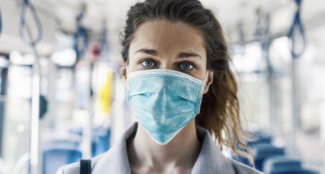 Imagen de una mujer con mascarilla dentro de un autobús.