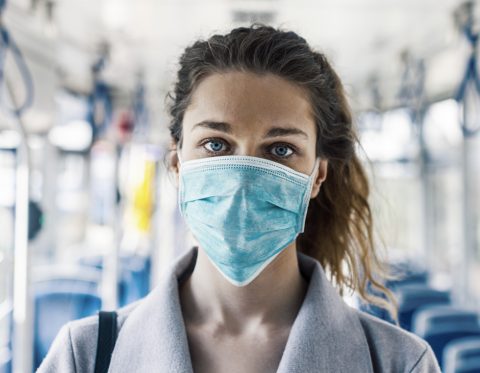 Imagen de una mujer con mascarilla dentro de un autobús.