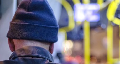 Persona mayor de espaldas en interior de transporte